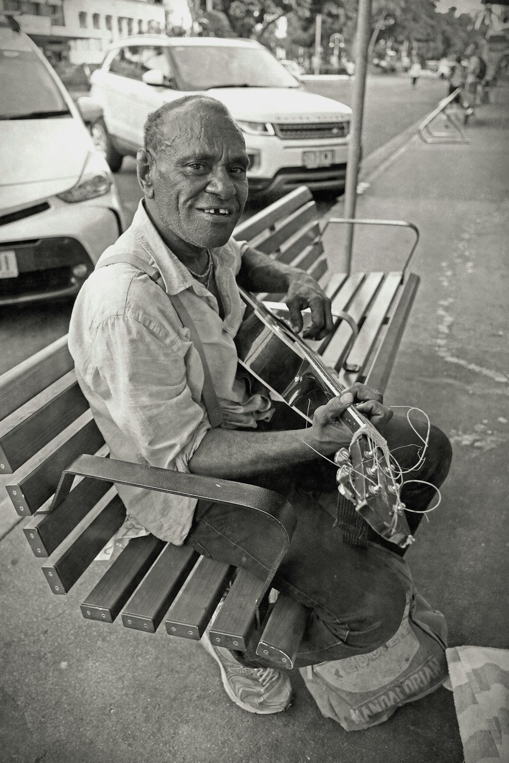 a black and white photo of a man sitting on a bench