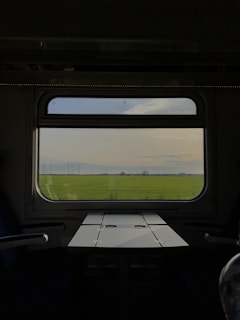 a view of a field from inside a train