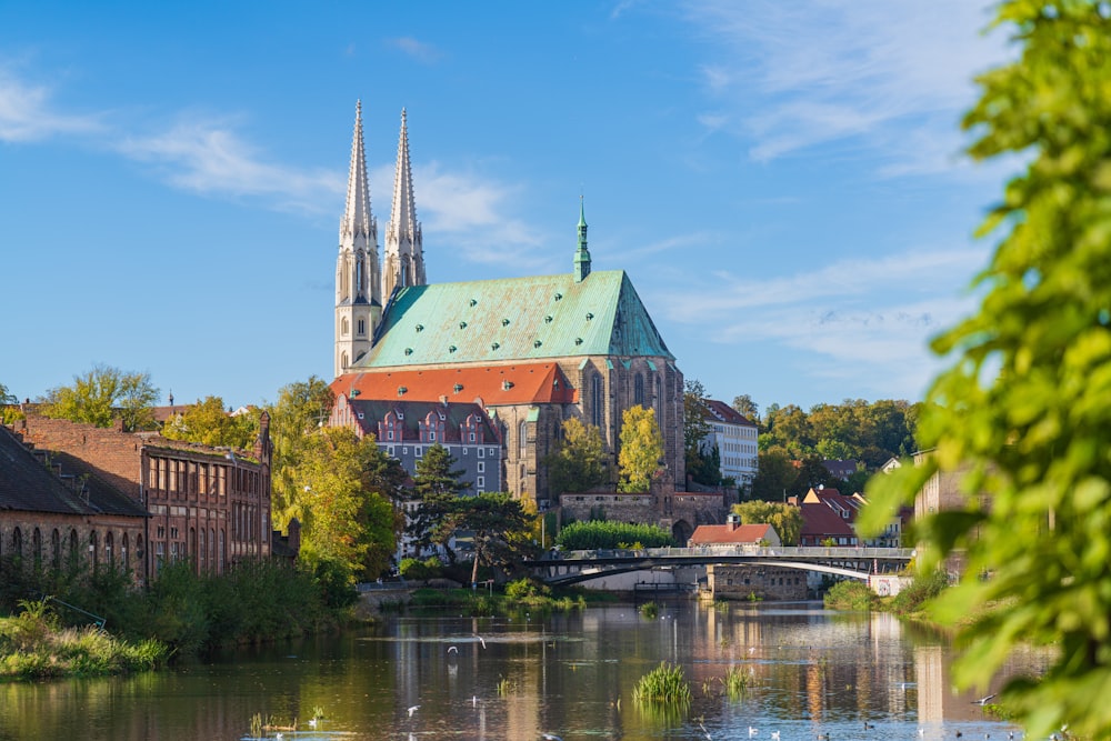 a large cathedral towering over a city next to a river