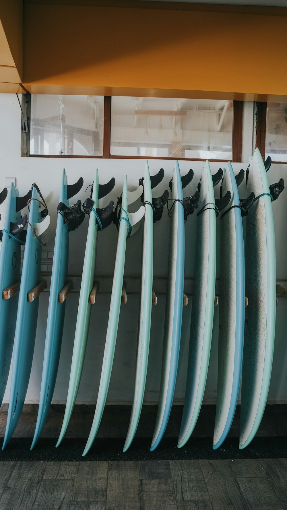 a bunch of surfboards lined up against a wall