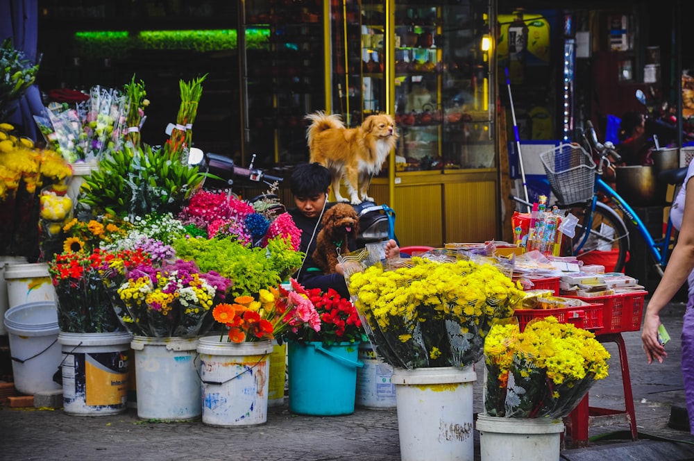 a woman looking at flowers at a flower market