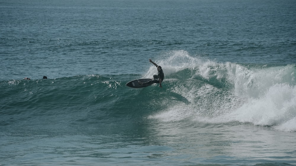 a man riding a wave on top of a surfboard