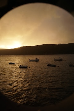 A calm bay at sunset with several boats anchored, highlighting peaceful water service.