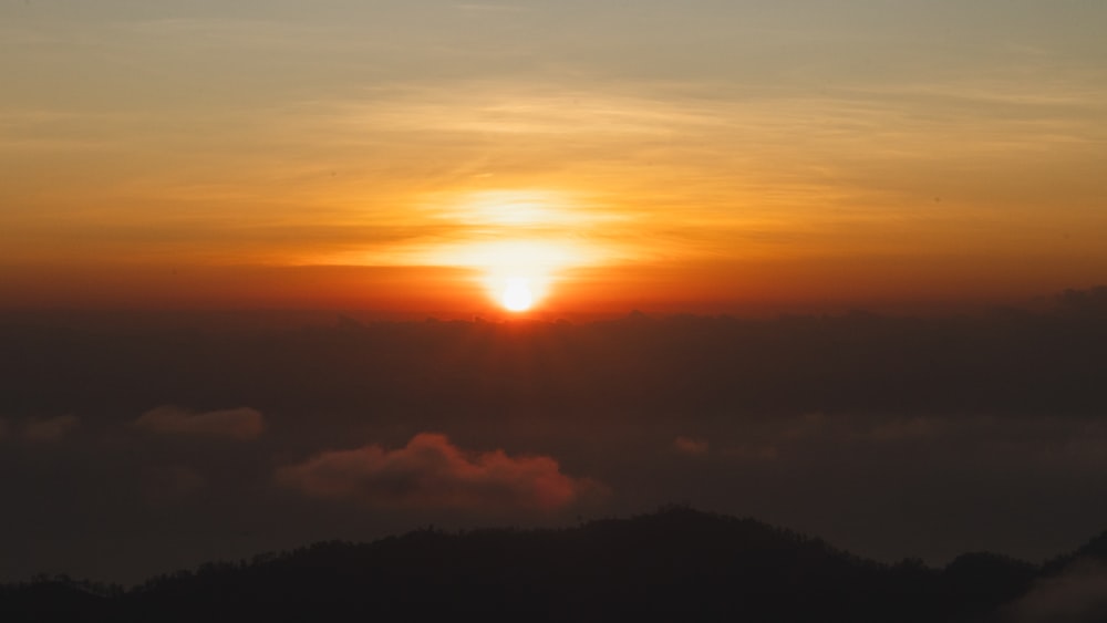 the sun is setting over the clouds in the sky