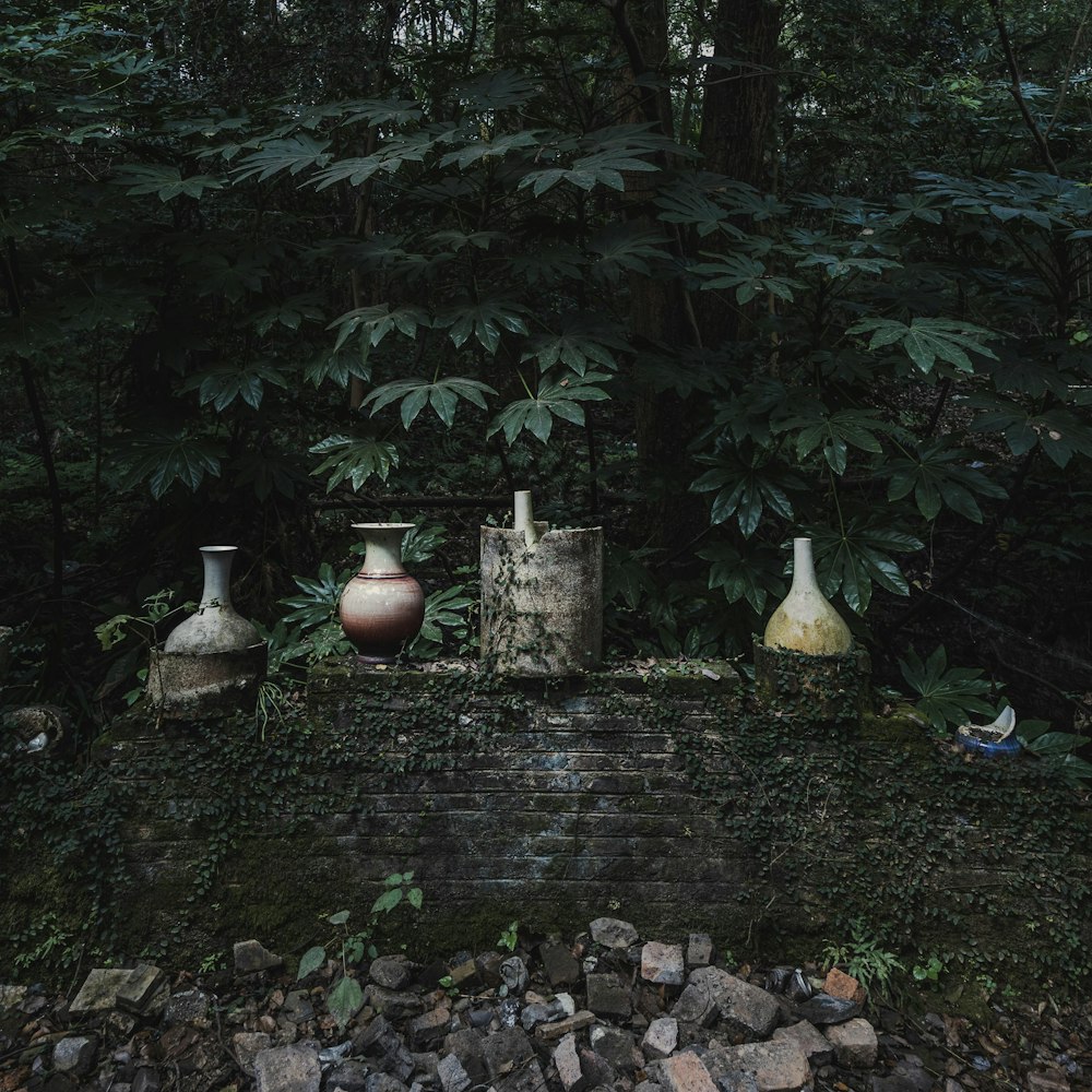 a group of vases sitting on top of a brick wall