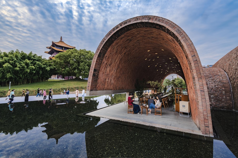 a group of people sitting at a table under a bridge