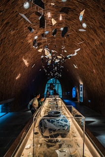 Curator reviewing real-time environmental data on a tablet, surrounded by priceless artifacts.