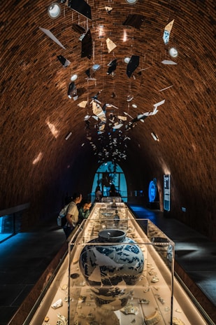 Curator reviewing real-time environmental data on a tablet, surrounded by priceless artifacts.