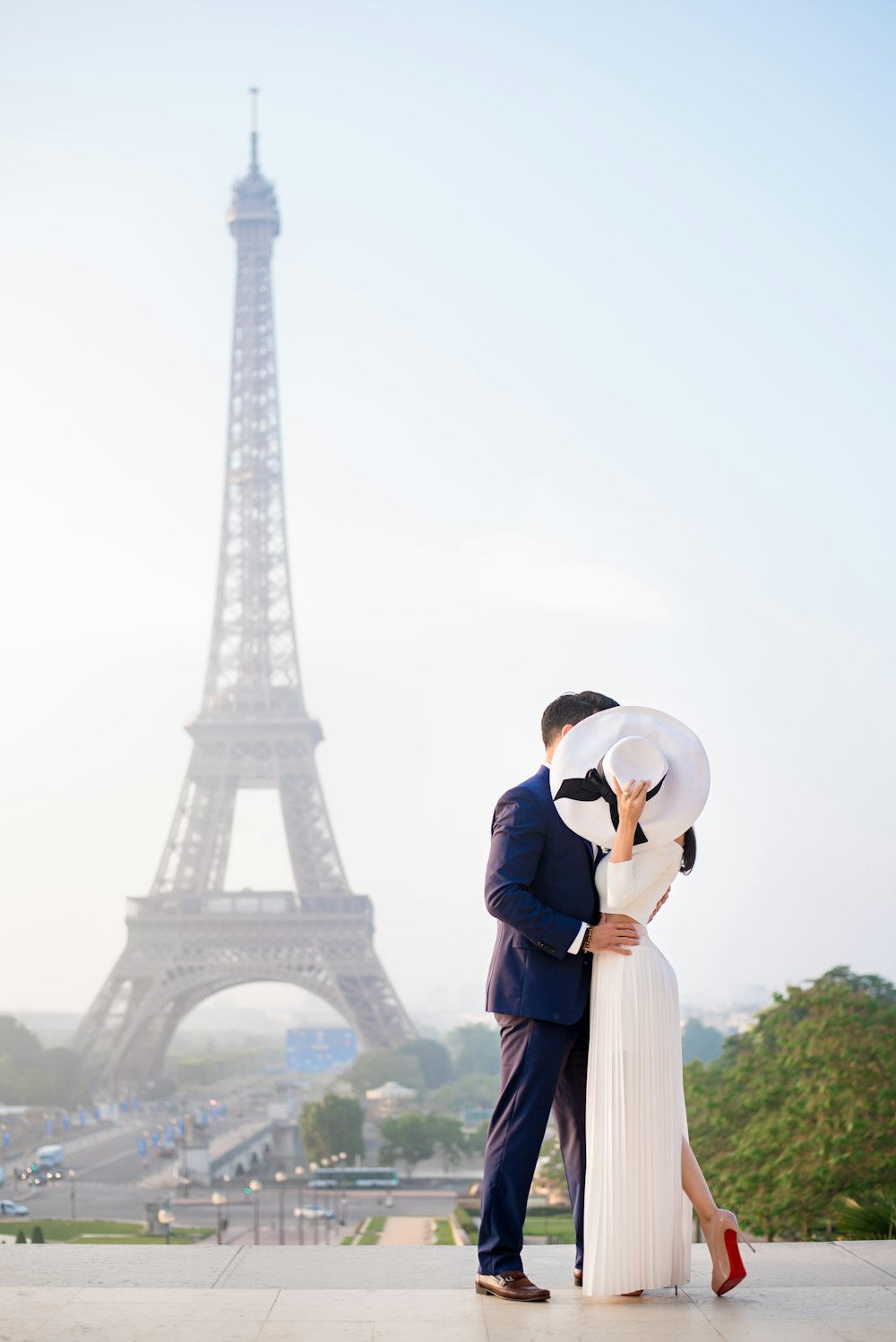 Un hombre y una mujer besándose frente a la Torre Eiffel