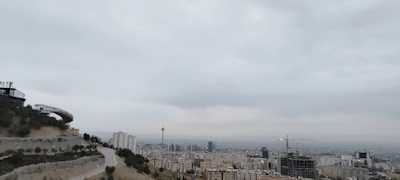 A panoramic view of a city district undergoing transformation with cranes and scaffolding.