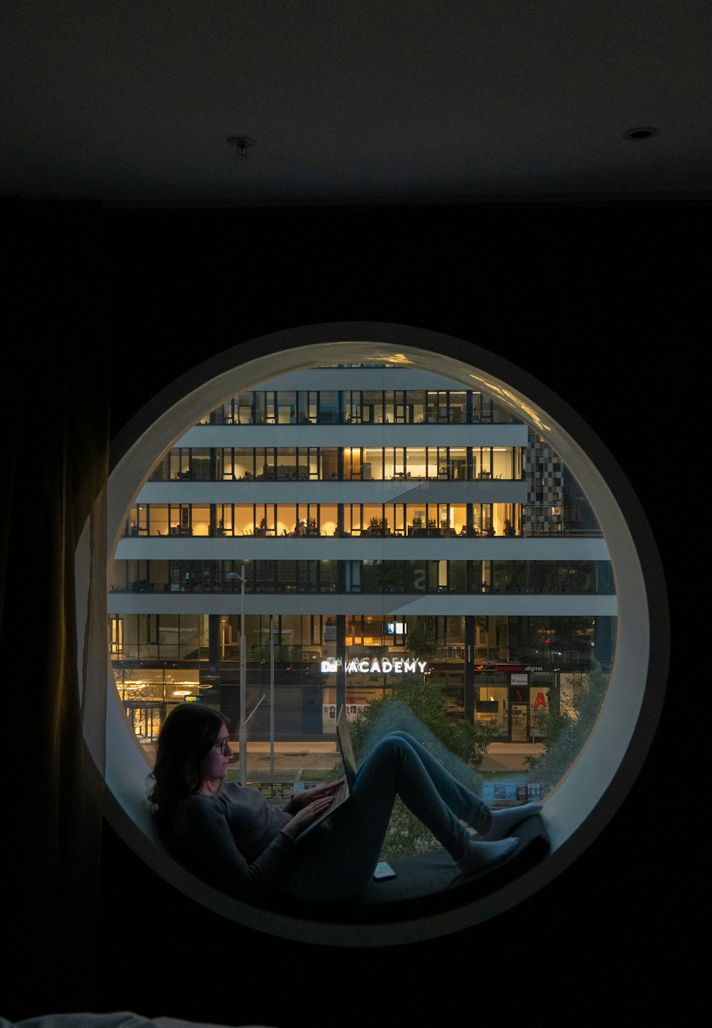 a woman sitting in a chair looking out a window