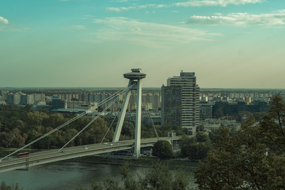 a bridge over a river with a city in the background