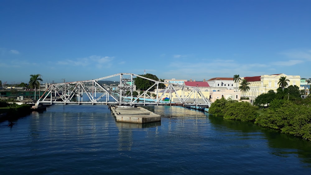 a bridge over a body of water with buildings in the background