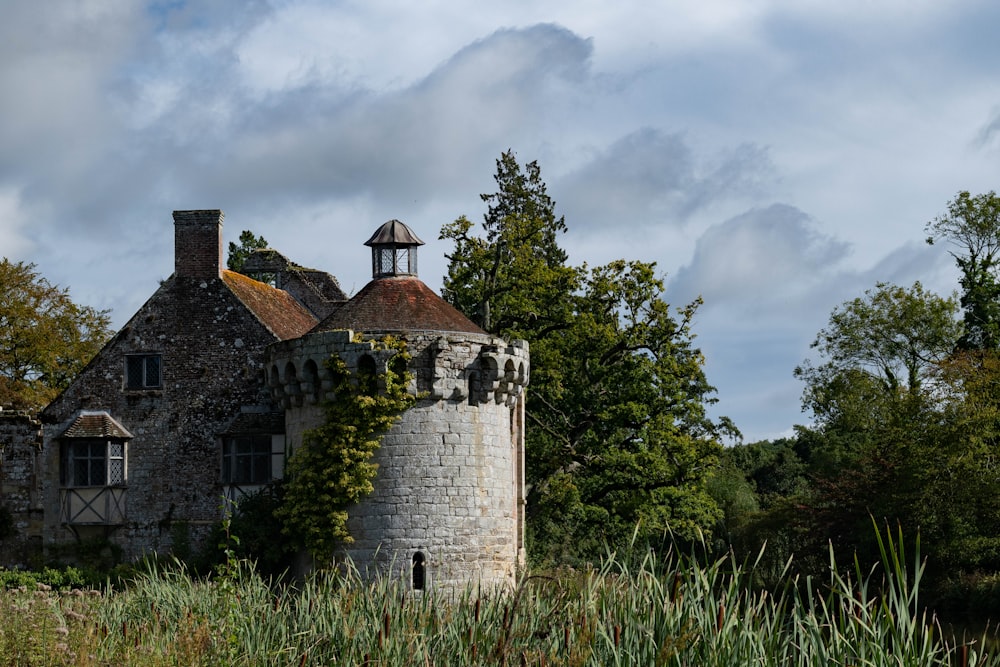 an old stone building surrounded by trees and grass