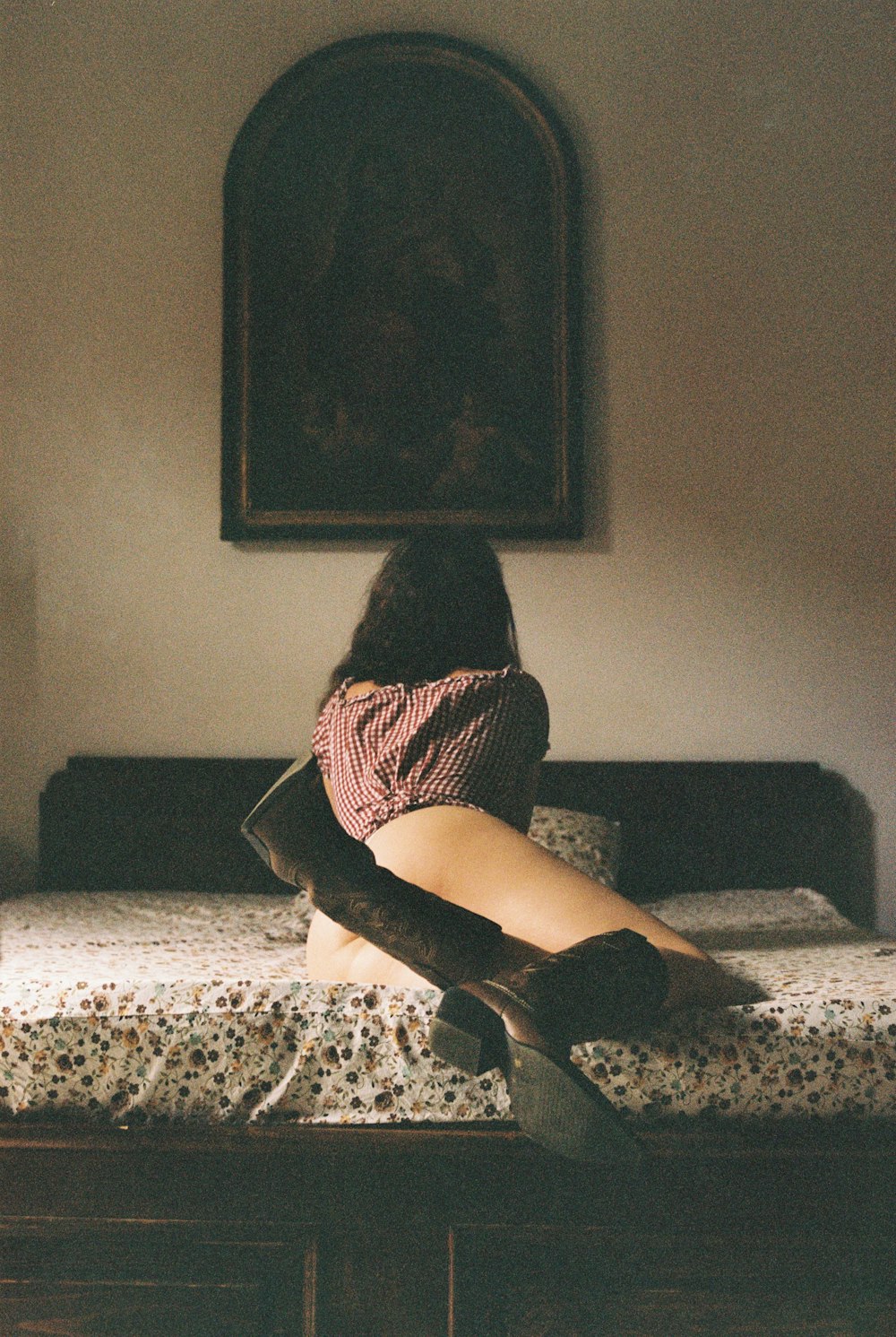 絵の隣のベッドの上に座る女性