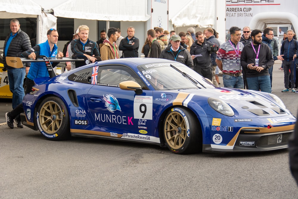 a blue race car with gold rims on a race track