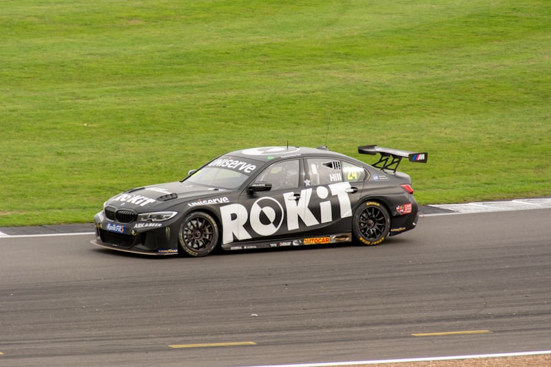 a car driving on a race track with grass in the background