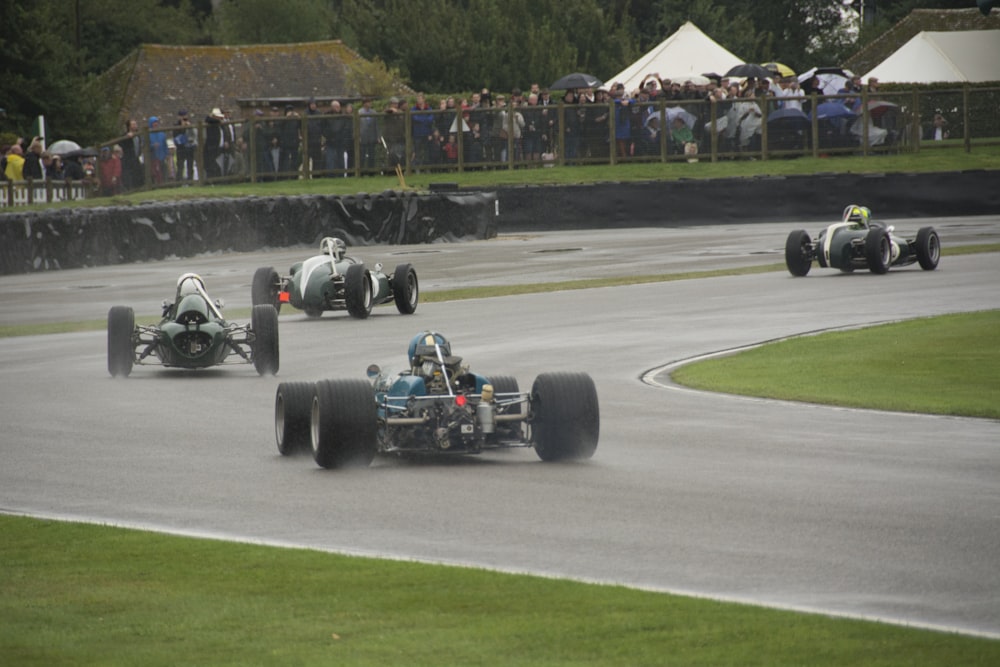 a group of racing cars driving down a race track