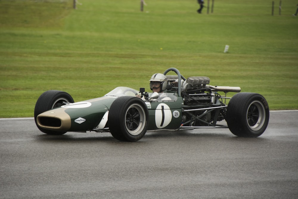 a green race car driving down a race track