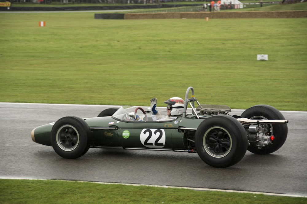 a green race car driving down a race track