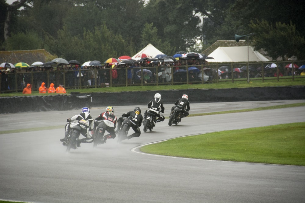 a group of people riding motorcycles on a race track
