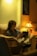 A person reading a book in a cozy chair with a warm light.