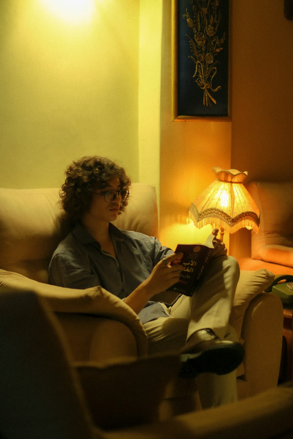 a woman sitting in a chair reading a book