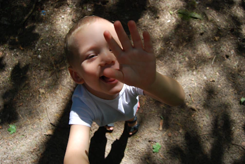 Candid shot of a child reaching for a snack, smiling naturally in the sunlit minimarket.