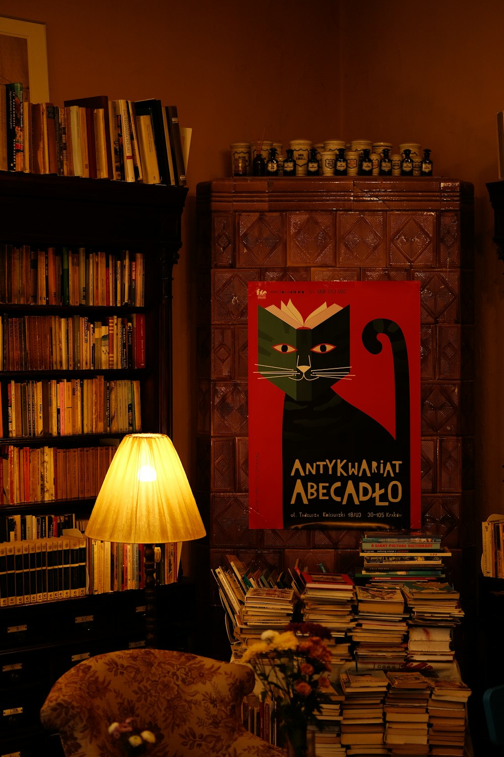 a room filled with lots of books and a lamp