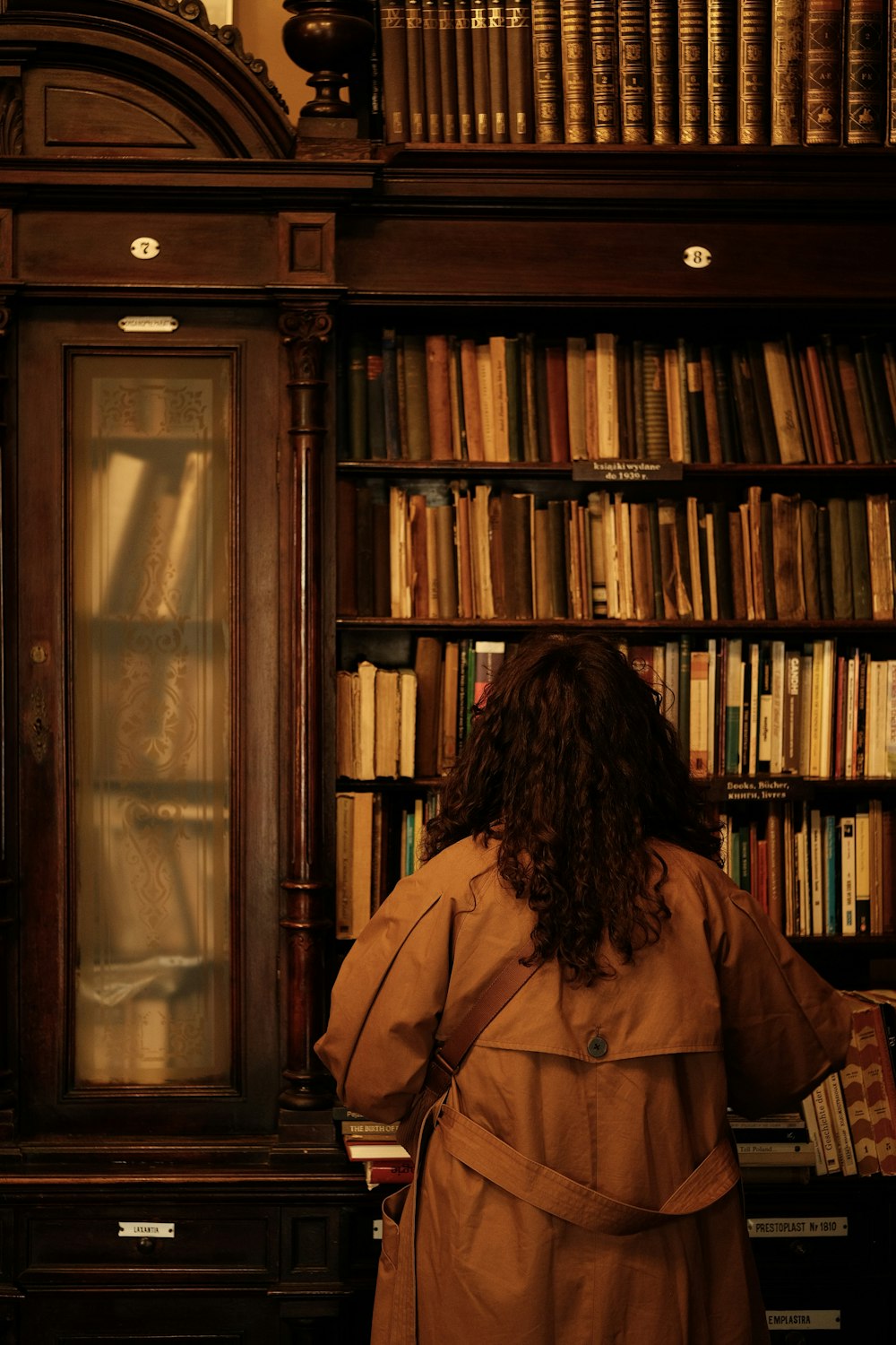 a woman standing in front of a book shelf