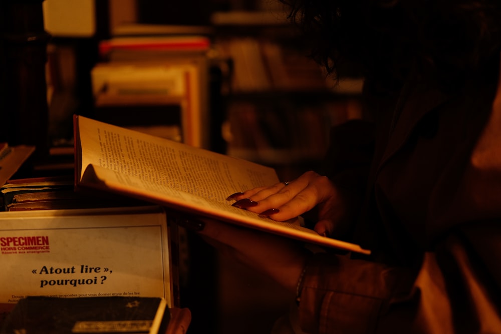 a woman reading a book in a dark room