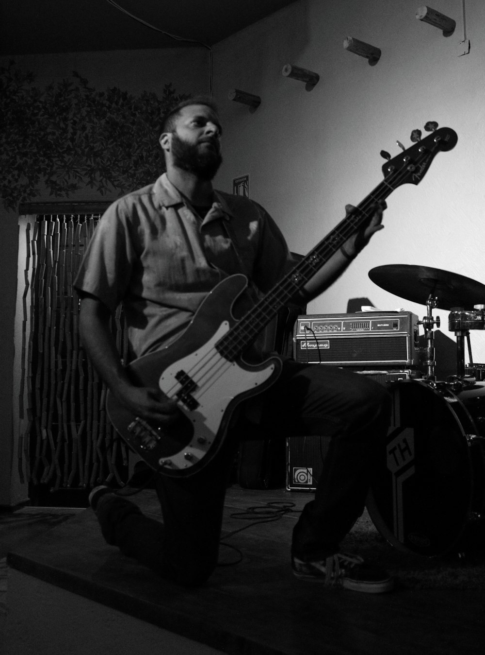 a man playing a bass guitar in a room