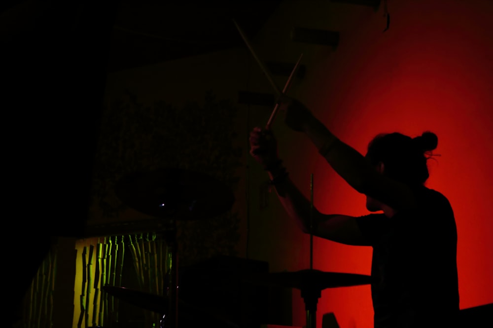 a person holding a stick in a dark room