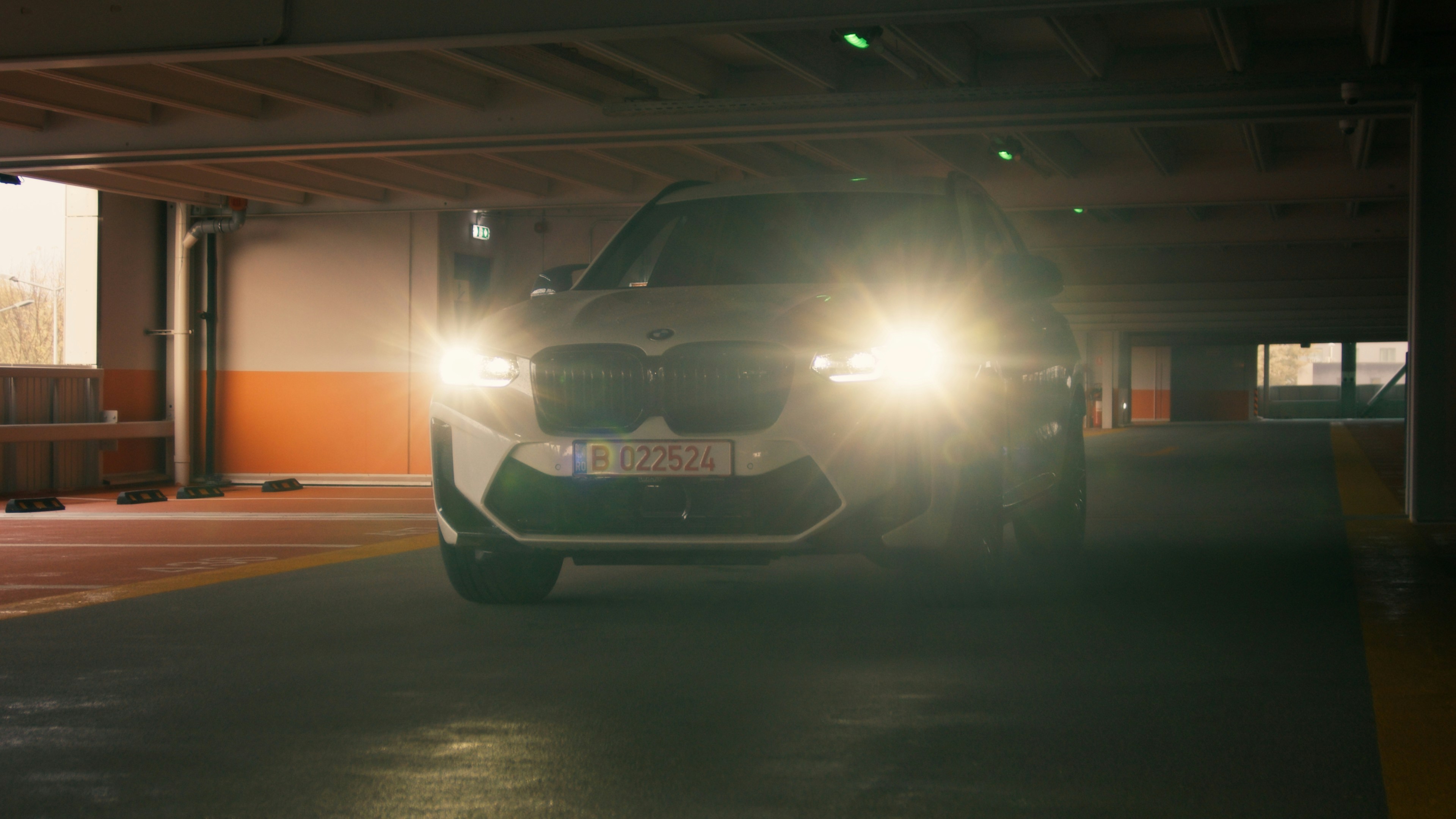 a white car driving through a parking garage