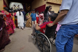 a group of people standing around a man in a wheel chair