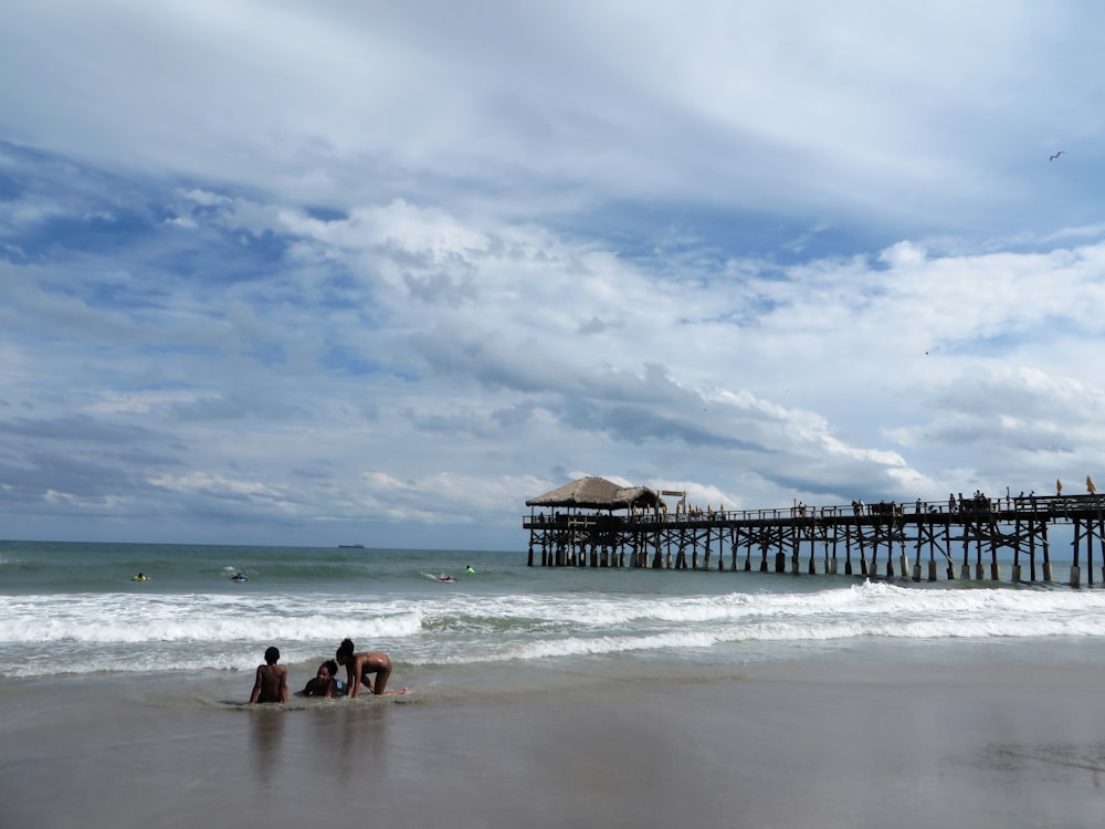 a group of people sitting on top of a sandy beach