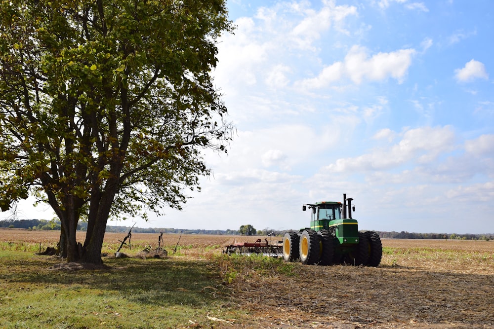 a tractor parked in a field next to a tree