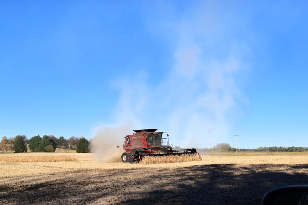 a red tractor is driving through a field