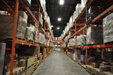 A warehouse filled with organized shelves of pharmaceutical boxes ready for distribution.