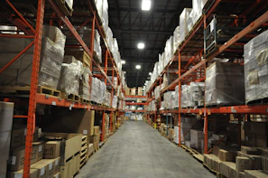 Warehouse workers organizing packages in a brightly lit distribution center.