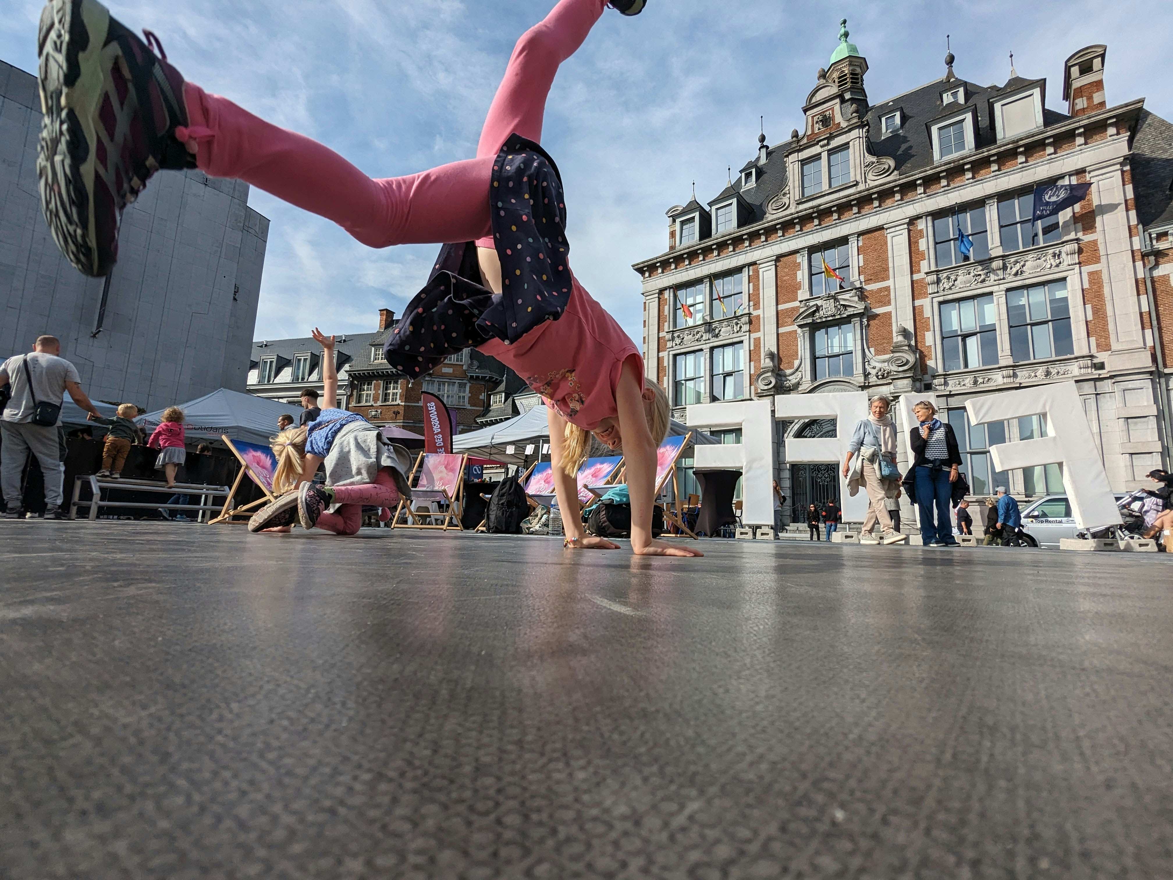 a woman doing a handstand on a city street