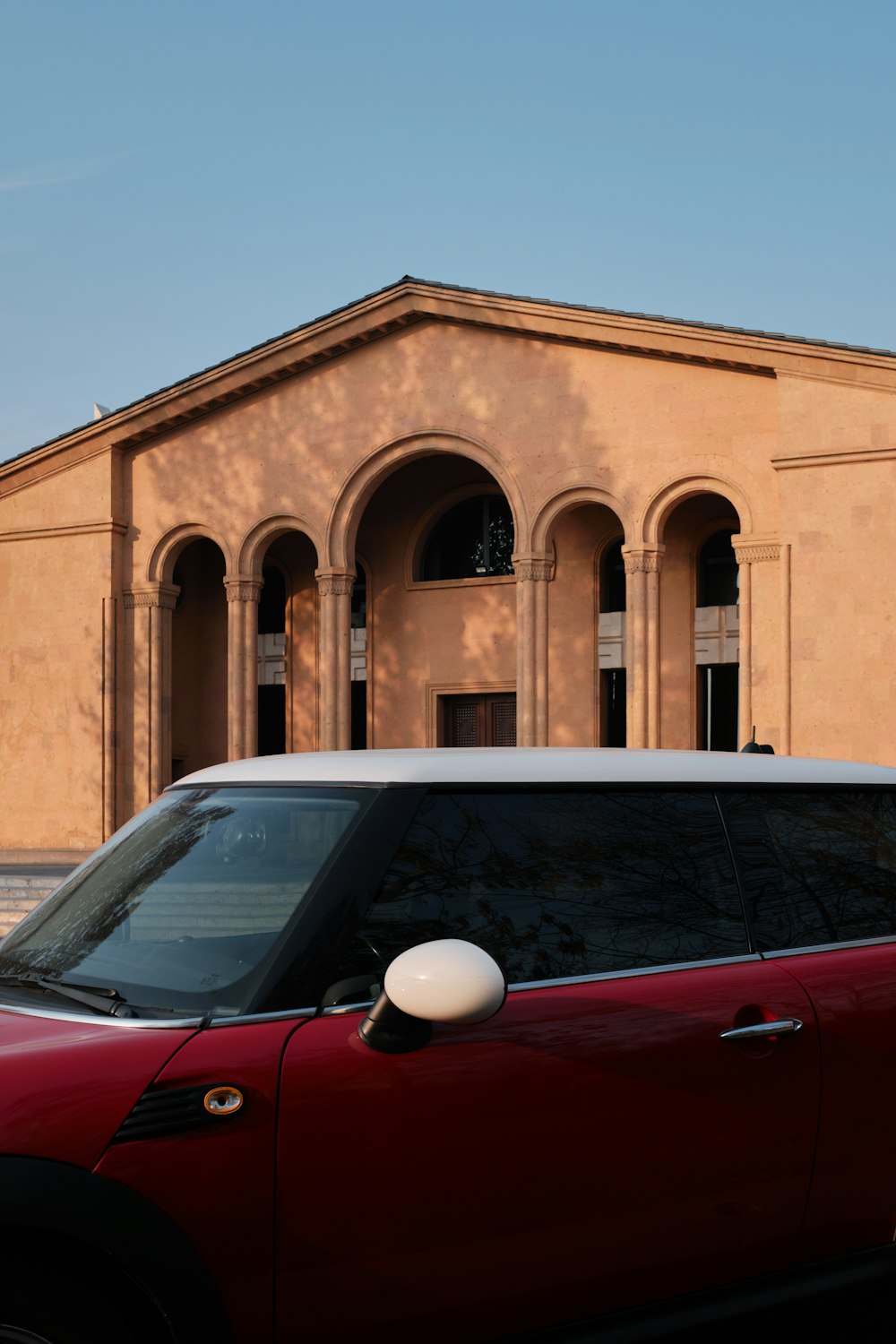 a red minivan parked in front of a building