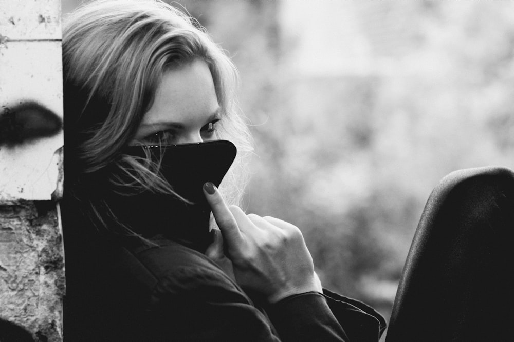 a black and white photo of a woman talking on a cell phone