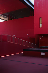 A finished building exterior featuring clean lines highlighted by bold red accents.