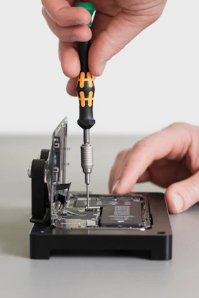 Close-up of hands dismantling old electronic devices for recycling.