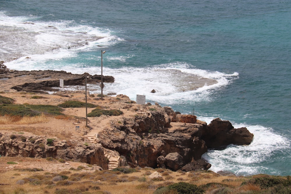 a rocky cliff overlooks the ocean and beach