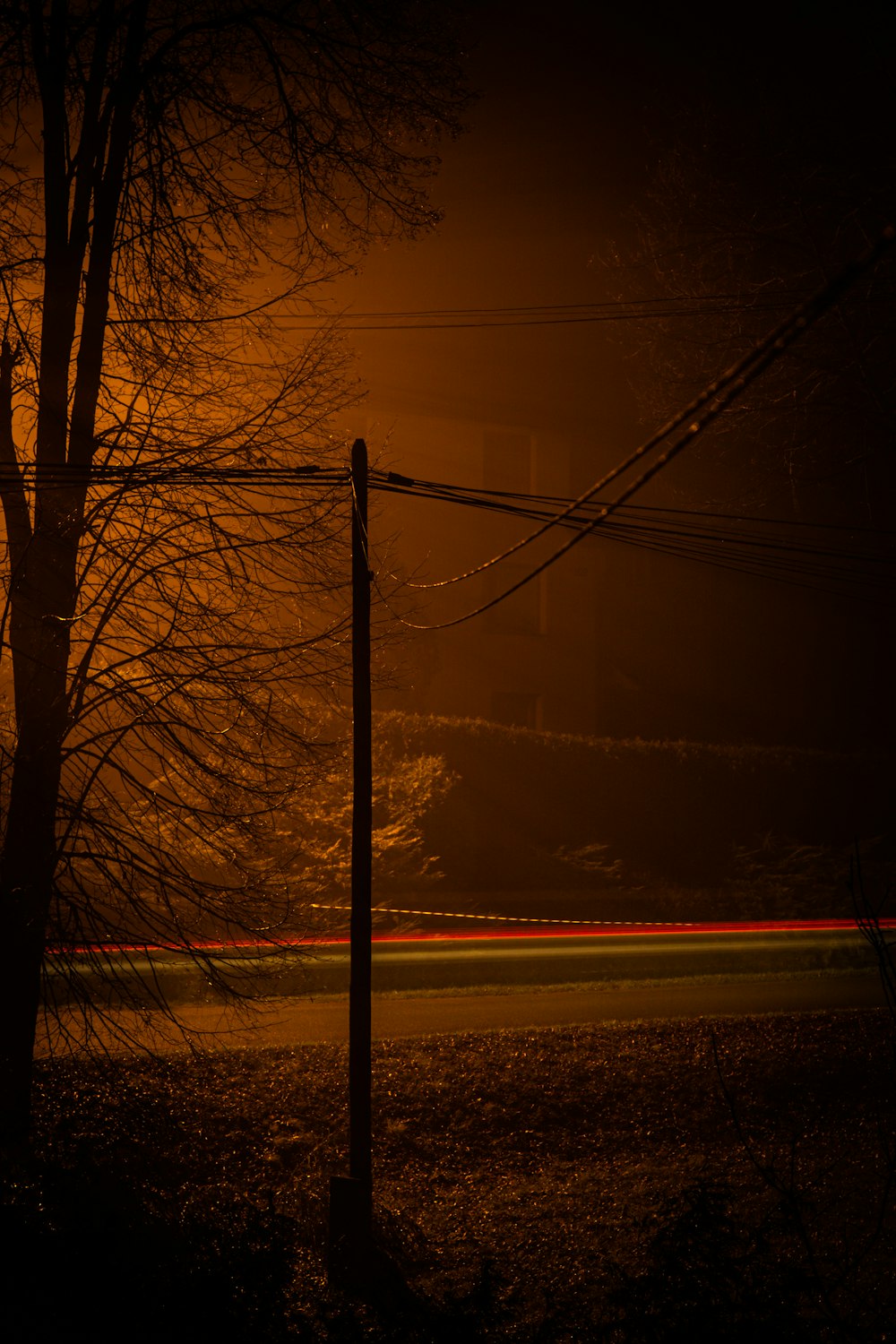 a dark street at night with a street light in the background