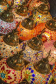 Close-up of a glowing Turkish mosaic lamp with intricate colorful glass pieces.