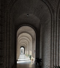 a long hallway with brick walls and arches