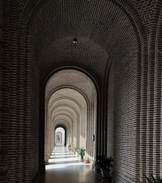 a long hallway with brick walls and arches